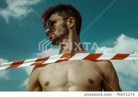 Strong commercial face male model wearing eyewear on blue sky with clouds Strong commercial face male model wearing eyewear on blue sky with clouds 76655254