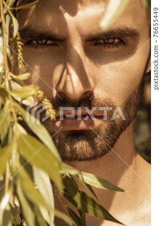 Sexy beautiful stripped male model on the nature background with sand and sky on the beach on the sunset Sexy beautiful stripped male model on the nature background with sand and sky on the beach on the sunset 76655449