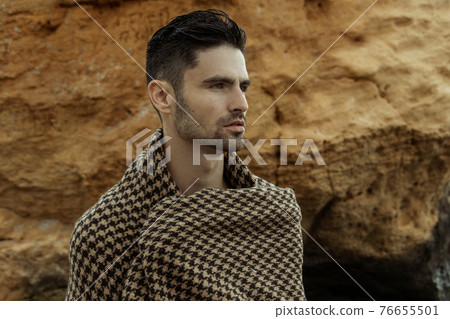 Sexy beautiful striped male model on the nature background with sand and sky on the beach on the sunset Sexy beautiful striped male model on the nature background with sand and sky on the beach on the sunset 76655501