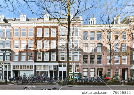 Facade of old brick residential building on city street 76656833