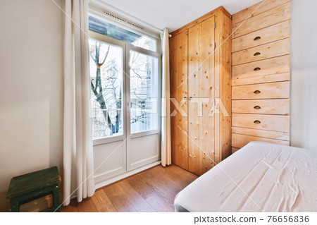 Light bedroom with wooden wardrobe 76656836