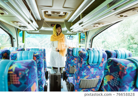 muslim woman doing eid mubarak traveling back to her hometown by riding a bus muslim woman doing eid mubarak traveling back to her hometown by riding a bus 76658828