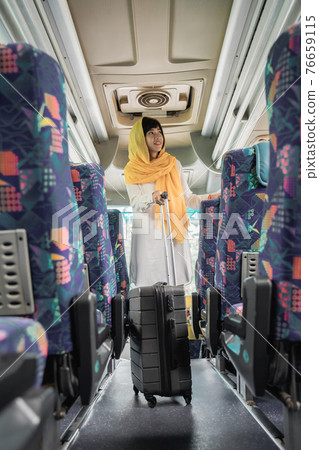 muslim woman doing eid mubarak traveling back to her hometown by riding a bus 76659115