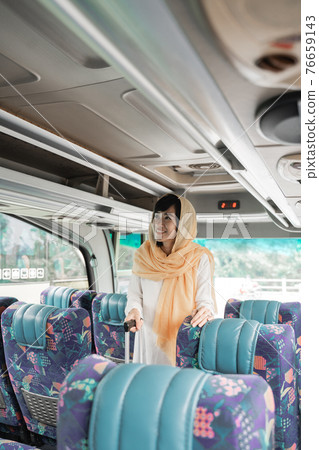 muslim woman doing eid mubarak traveling back to her hometown by riding a bus muslim woman doing eid mubarak traveling back to her hometown by riding a bus 76659143