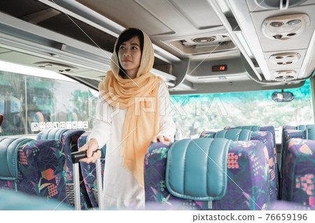 muslim woman doing eid mubarak traveling back to her hometown by riding a bus 76659196