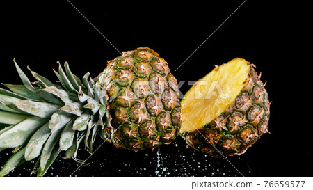 Pineapple falling on a black background. Pineapple falling on a black background. 76659577