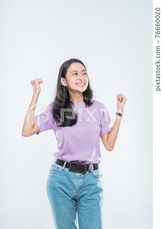 Asian young girl smiling happy while clenched into fists and raised two hands 76660020