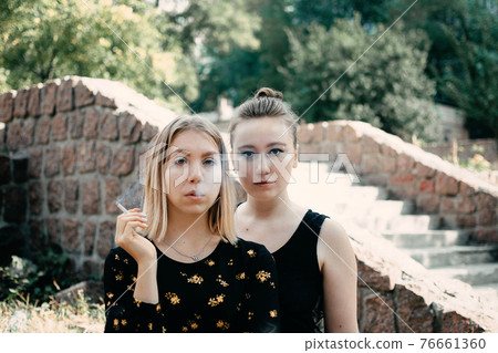 LGBT, Lesbian, gay, bisexual, and transgender LGBT social movements. Two Young lesbians girls walking outdoors. Two girlfriends in love outdoors portrait 76661360