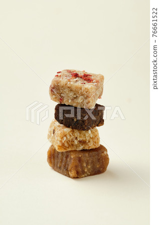 Four candies from different raw foods stacked in a pile on a white background. The concept of raw food and vegetarianism. Four candies from different raw foods stacked in a pile on a white background. The concept of raw food and vegetarianism. 76661522