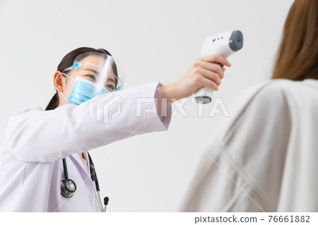 用非接觸式溫度計測量體溫的女醫生 76661882