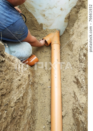 The employee connects the sewer pipes and connects them to the sump. The employee connects the sewer pipes and connects them to the sump. 76661932