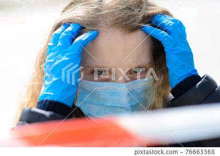 Portrait of sad caucasian child in face mask on closed playground outdoor. 76663368