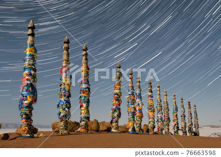 Night starry sky over Shaman ritual pillars on the island of Olkhon lake Baikal. 76663598