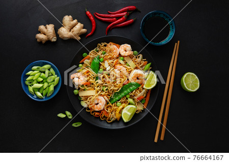 Asian noodles on plate on dark background Asian noodles on plate on dark background 76664167