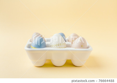 Easter eggs in egg box on pastel background Easter eggs in egg box on pastel background 76664488