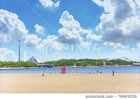[神奈川/橫濱] 八景島海洋樂園在背景中，一名年輕人在海之公園海灘的監視塔前踢足球。 76665039