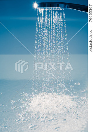 shower filling a bathtub with water stream 76665567