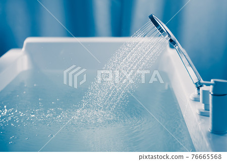 shower filling a bathtub with water stream 76665568