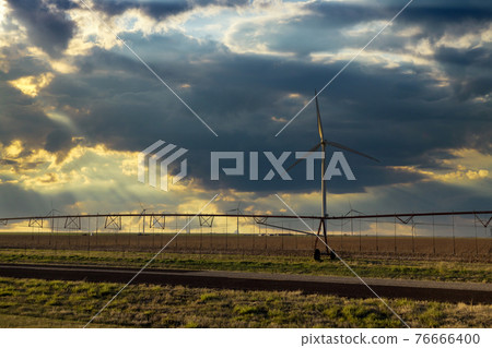 Agriculture irrigation machine field landscape with wind turbines windmill energy farm the beautiful sunset in Texas Agriculture irrigation machine field landscape with wind turbines windmill energy farm the beautiful sunset in Texas 76666400