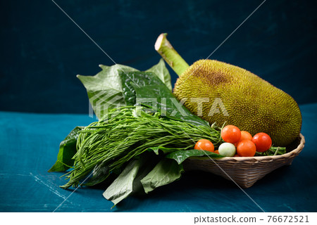 Young jackfruit and local vegetables in a basket 76672521