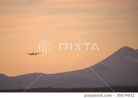 Airliner flying in the sunset sky Airliner flying in the sunset sky 76674932