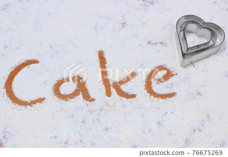 Word cake written in flour and cookie cutters. Baking concept Word cake written in flour and cookie cutters. Baking concept 76675269