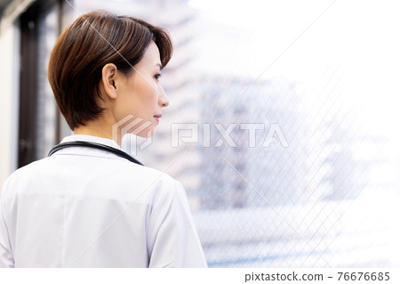 Back view of a female doctor thinking about treatment policy and medical system 76676685