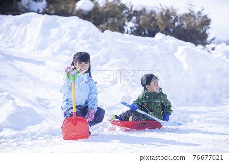 Brothers playing in the snow 76677021
