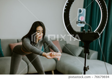Virtual online fitness. Woman virtual workout at home living room Virtual online fitness. Woman virtual workout at home living room 76679694