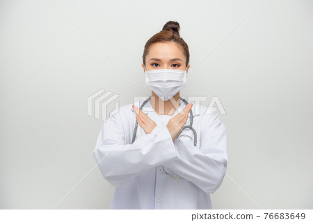 Serious-looking asian female doctor in medical mask, white coat make stop, cross sign, forbid coming outside Serious-looking asian female doctor in medical mask, white coat make stop, cross sign, forbid coming outside 76683649