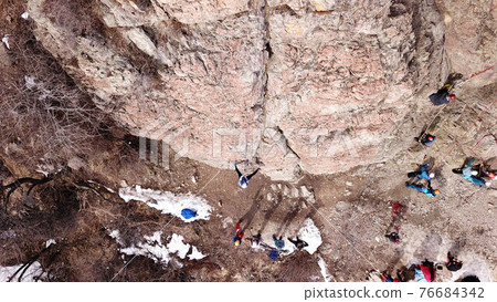 A group of people are engaged in rock climbing. A group of people are engaged in rock climbing. 76684342