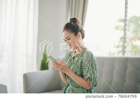 Attractive Vietnamese woman using application on her smartphone Attractive Vietnamese woman using application on her smartphone 76684709