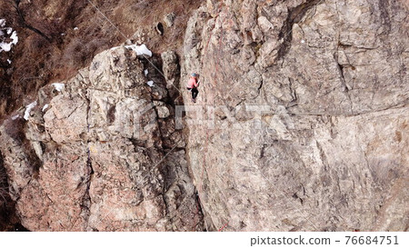 A group of people are engaged in rock climbing. A group of people are engaged in rock climbing. 76684751