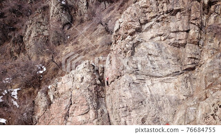 A group of people are engaged in rock climbing. A group of people are engaged in rock climbing. 76684755