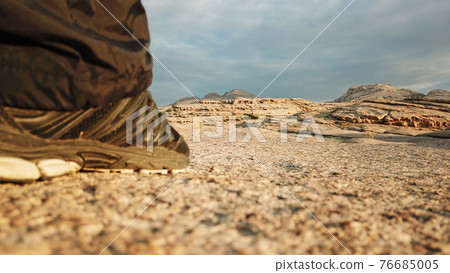 Men's legs in sneakers in the mountains. 76685005