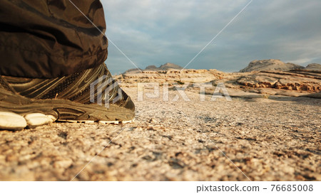 Men's legs in sneakers in the mountains. 76685008