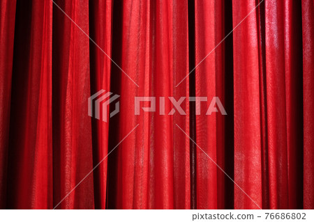 Luxury red closed curtain with light spots in a theater 76686802