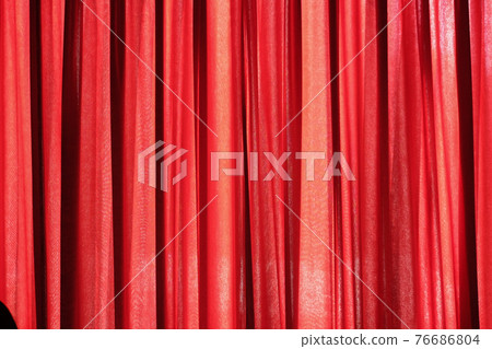 Luxury red closed curtain with light spots in a theater 76686804