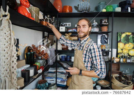 Bearded man checking store assortment with tablet 76687642