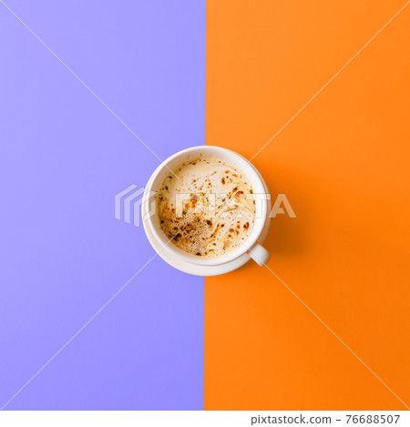 A cup of black coffee with milk and foam on lilac orange background. Top view. Flat lay. A cup of black coffee with milk and foam on lilac orange background. Top view. Flat lay. 76688507