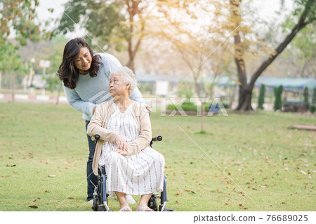 Help and care Asian senior or elderly old lady woman patient sitting on wheelchair at park in nursing hospital ward 76689025