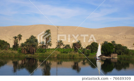 Egypt Nile river side view felucca boat and telephone signal tower Egypt Nile river side view felucca boat and telephone signal tower 76689309