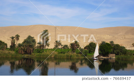 Egypt Nile river side view felucca boat and telephone signal tower Egypt Nile river side view felucca boat and telephone signal tower 76689437