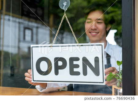 Barista or coffee maker man hold banner of open for the symbol of ready to service for customer 76690436