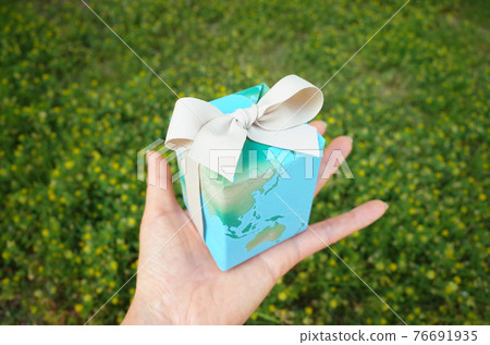 Hand holding an earth gift Green Hand holding an earth gift Green 76691935