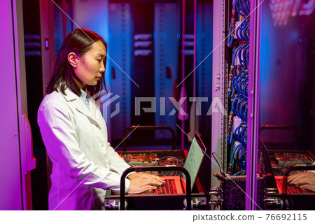 Asian IT specialist performing diagnostic tests 76692115