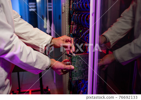 Man inserting blade server into cabinet 76692133