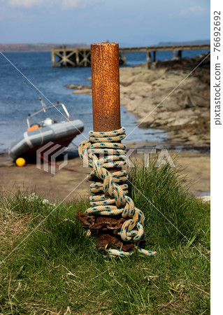 Rope and Chain Wrapped Around a Post at a Coastal Harbour 76692692