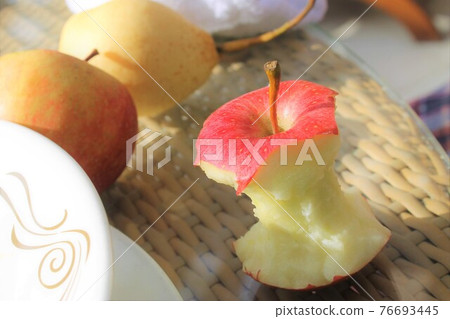 Bitten apple on the table 76693445