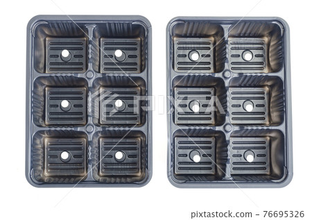 Black plastic cassettes for growing plant seedlings on white background. 76695326